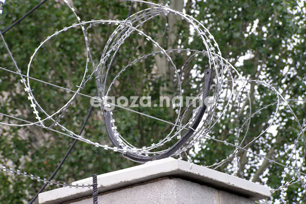 Crumpled concertina barrier and improperly installed tension wire, third party contractor